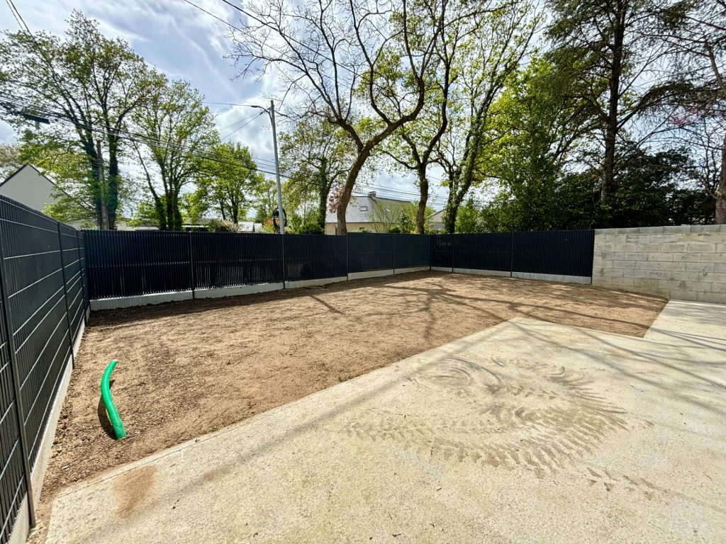 Terrain réaménagé avec nouvelle clôture et préparation du gazon